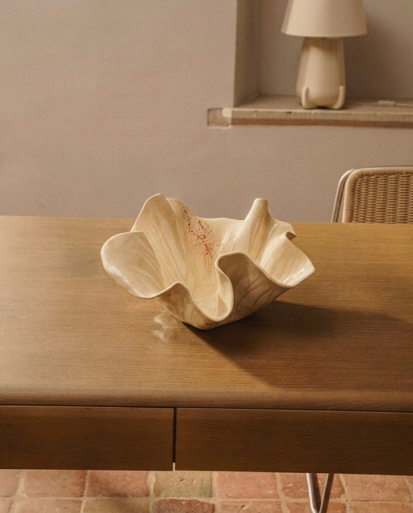 Escultura orgánica grande de cerámica de autor titulada Flor Calima de 25 cm de altura, destacada como centro de mesa decorativo sobre una gran mesa de comedor de madera.