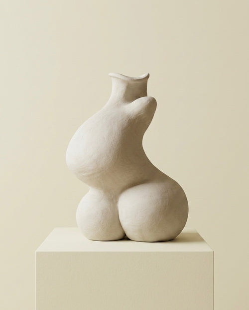 Silueta completa de perfil de la escultura de cerámica beige Calima Magna 2 sobre un pedestal cúbico, ideal para decoración de interiores minimalista.