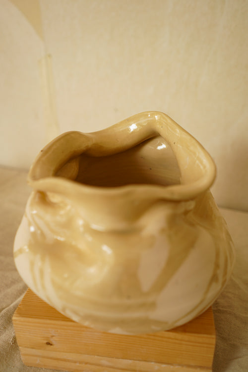 Escultura de cerámica artesanal Calima Fuentón con boca de bordes ondulados y acabado de esmalte crema fluido.