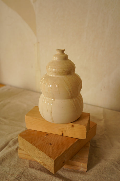 Pequeña escultura de cerámica artesanal Calima Little con niveles bulbosos y detalle de esmalte crema goteado.
