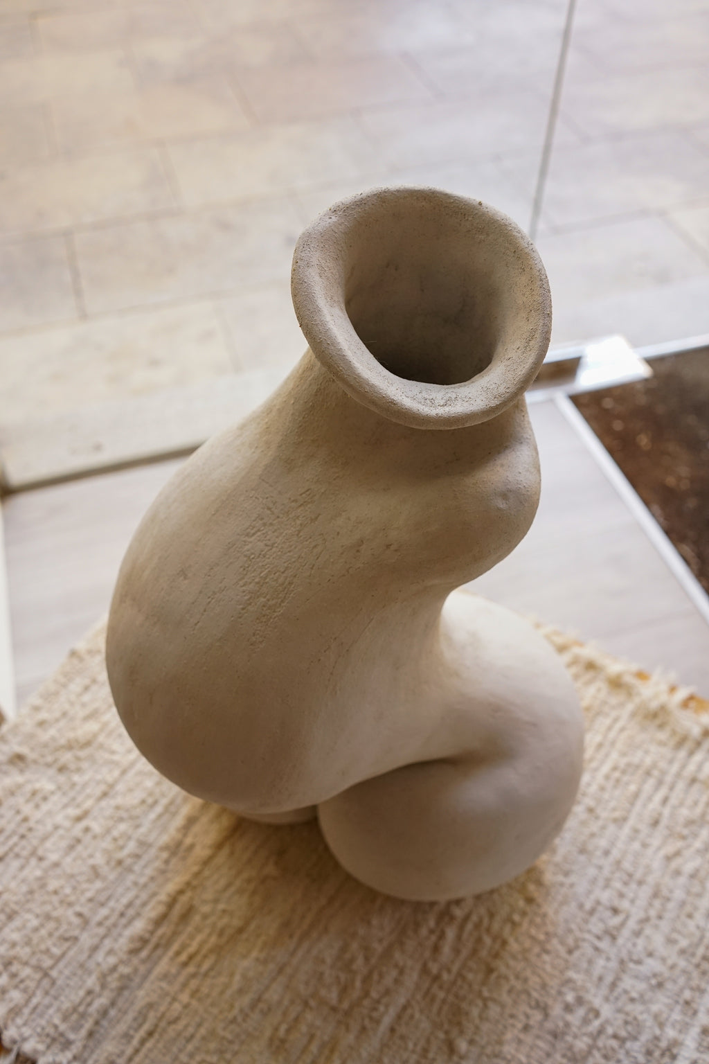 Primer plano de la embocadura amplia y la textura rústica de la pieza monumental de Cecilia Behrendt.