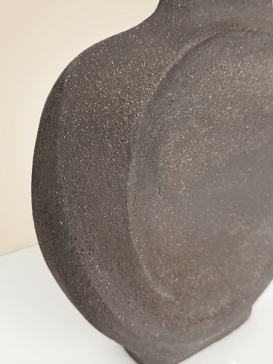 Plano medio de la escultura que permite apreciar la base sólida de 25 cm de ancho y la transición orgánica hacia el cuerpo esbelto de la obra.