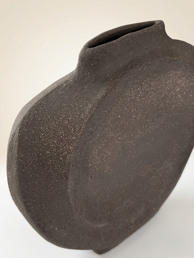 La escultura "GESTO" en una toma de ángulo bajo, enfatizando su altura de 27 cm y su poderosa presencia visual como objeto de diseño.