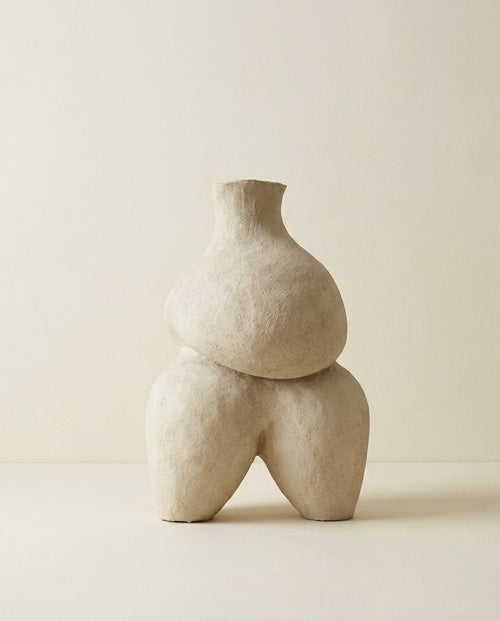 Vista completa de la escultura de cerámica beige Calima Magna 1 de Cecilia Behrend, mostrando su silueta abstracta y artesanal sobre un fondo neutro continuo.
