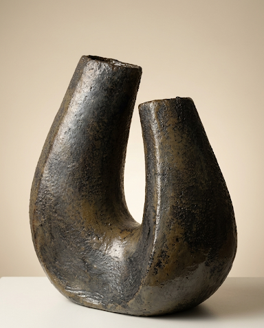 La escultura exhibida sobre un pedestal oscuro, demostrando su impacto visual como pieza central en un ambiente de diseño.