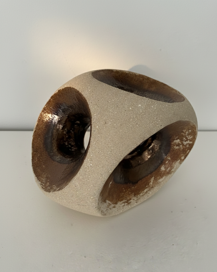 Toma de ángulo bajo dramática que destaca la volumetría de la escultura "HALO" y la sombra nítida proyectada hacia la derecha sobre la superficie blanca.
