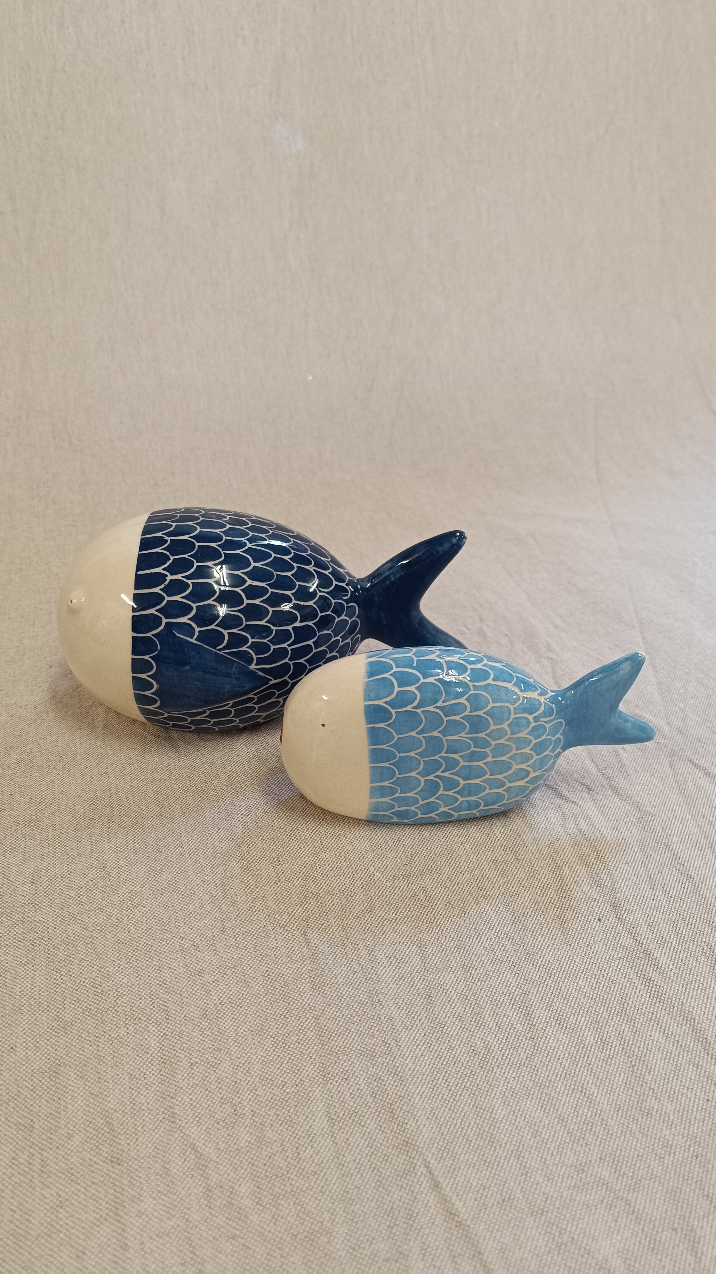 Pareja de esculturas de pez en cerámica de gres azul (celeste y cobalto) con patrón de escamas blancas, obra de Vicente Rivera para Sezme Decor.
