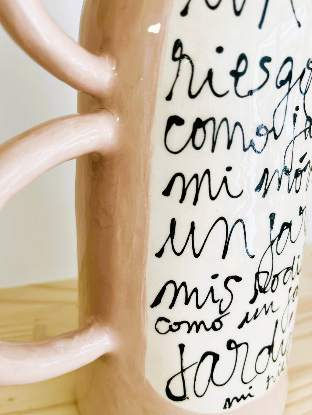 Detalle lateral de las tres asas laterales del Jarrón LETRA cerámico, mostrando la textura artesanal de la cerámica esmaltada.