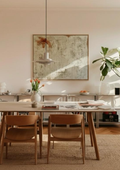 Obra "RAÍZ" de Irene Crespo en gran formato colgada sobre una mesa de comedor de madera, mostrando su integración en un espacio cálido y moderno.