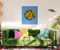 Mockup de la obra "Oro Verde" colgada en un salón moderno sobre un sofá verde, mostrando su escala y potencial decorativo.