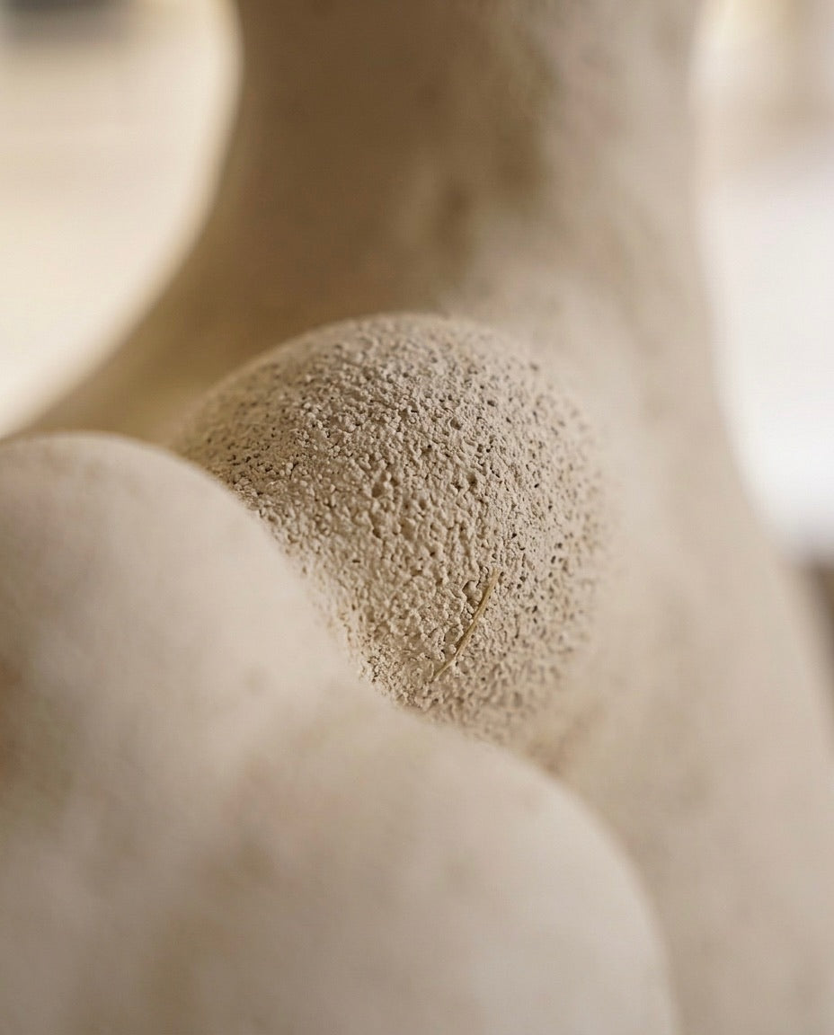 Primer plano macro que muestra el acabado arenoso, poroso y artesanal de la escultura de cerámica beige Calima Magna 2.